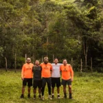 Grupo posa para foto em trecho do trekking do vale do pati, montanhas e vegetação ao fundo